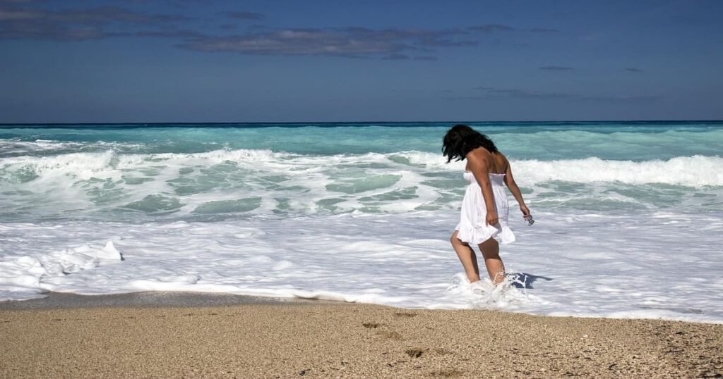 Persona relajándose en la playa durante sus vacaciones, reduciendo el estrés y mejorando su salud cerebral según la neurociencia